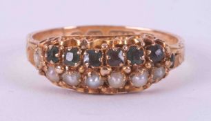 An antique 15ct yellow gold ring with an engraved patterned band and set with a row of