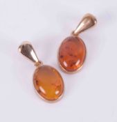 A pair of 9ct yellow gold drop earrings set with oval cabochon cut amber by the Scottish designer