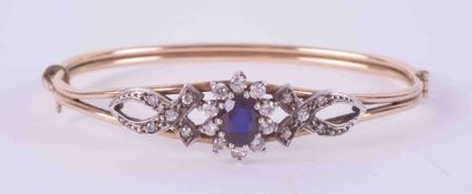 A yellow and white gold (no hallmarks but some marks on clasp) bangle with an intricate flower