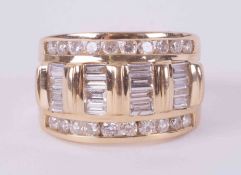 A 14k yellow gold wide band set with a mixture of round brilliant cut diamonds and baguette cut