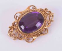 A 9ct yellow gold ornate filigree design brooch set with a large faceted oval amethyst measuring