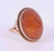 A 9ct yellow gold ring set with an oval cabochon cut amber measuring approx. 2.3cm x 2cm, 5.32g,