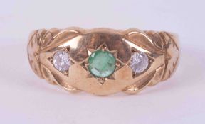 A 9ct yellow gold gypsy style ring set with a central emerald, approx. 0.17 carats and two white