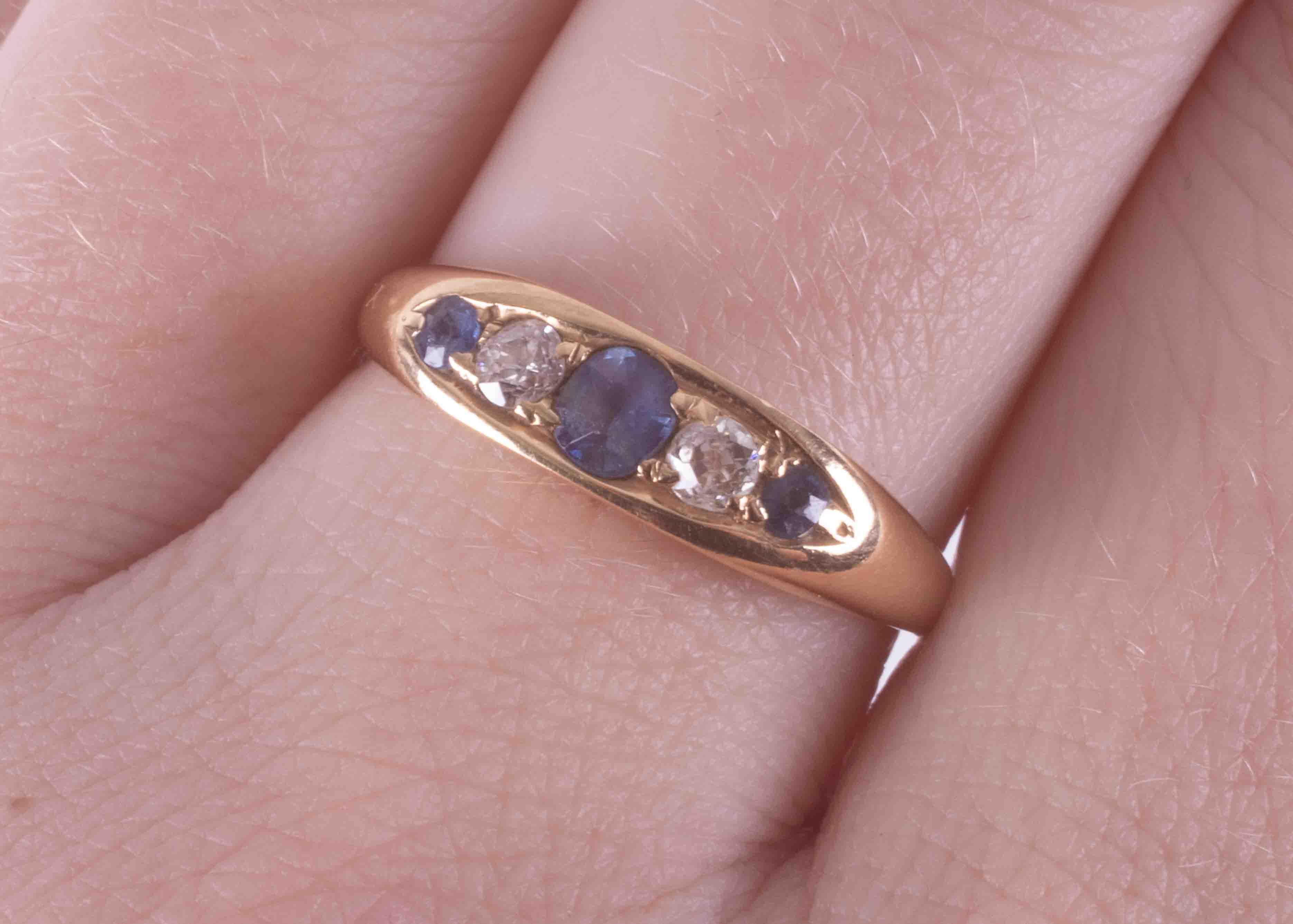 An 18ct yellow gold ring, set with two round cut sapphires & a central set oval cut - Image 2 of 2