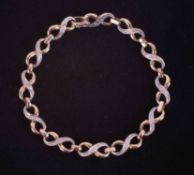 A 9ct yellow & white gold figure of eight link bracelet set with twenty-four small round brilliant