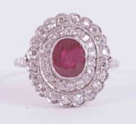 A platinum cluster ring set with a central oval cut ruby approx. 0.85 carats, surrounded by two rows