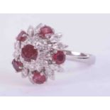 A 14ct white gold flower design cluster ring set with approx. 1.75 carats of round cut rubies