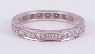 An 18ct white gold full eternity ring set with small old cut diamonds and engraving on the edges,