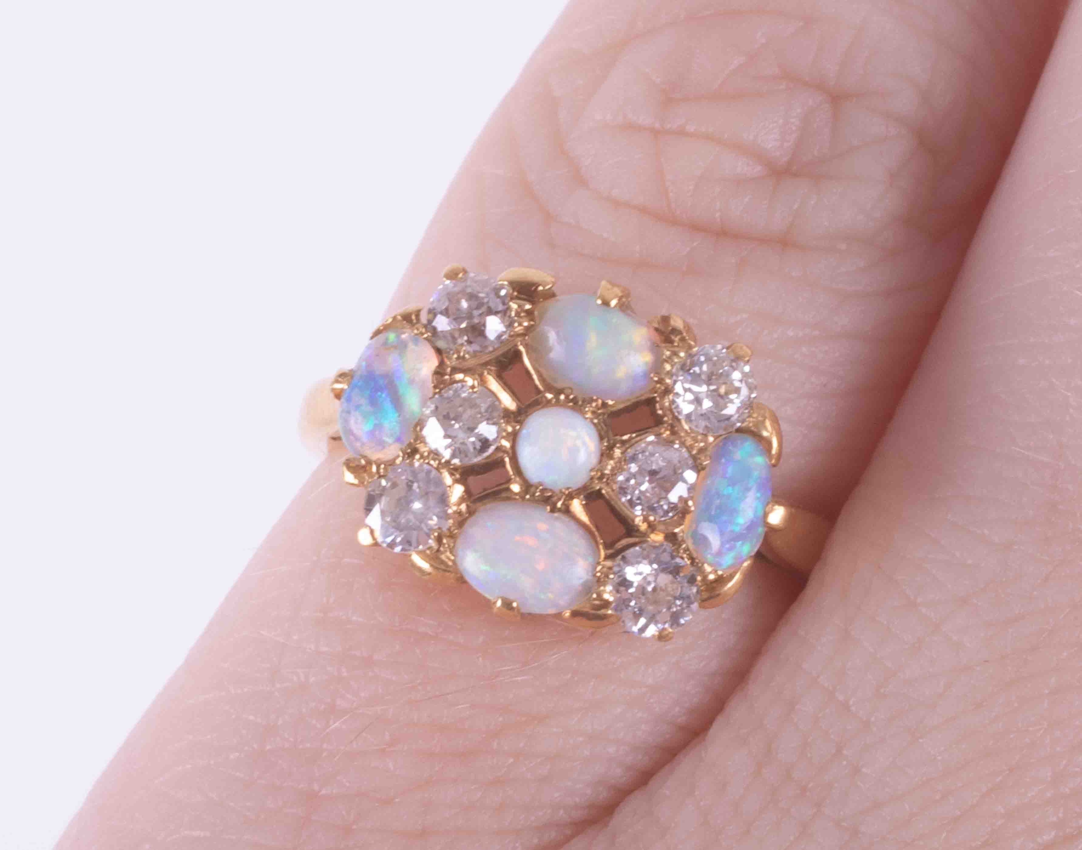 An 18ct yellow gold cluster style ring set with four oval cabochon cut white opals and a - Image 2 of 2