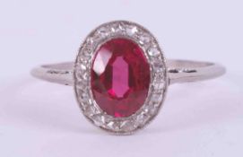 A platinum antique cluster ring set with an oval cut synthetic ruby approx. 0.75 carats surrounded