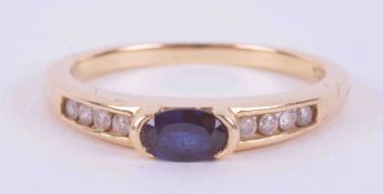 An 18ct yellow gold ring set with a central oval cut sapphire approx. 0.30 carats with four small