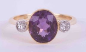 An 18ct yellow gold & platinum antique three stone ring set with a central oval cut amethyst,