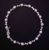 An 18ct white gold flower design line bracelet set with approx. 0.55 carats total weight of round