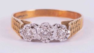 An 18ct yellow & white gold three stone ring set with three small round brilliant cut diamonds in an