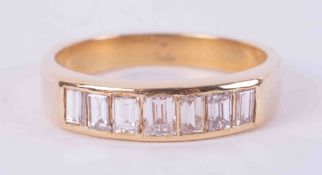 An 18ct yellow gold half eternity ring set with seven baguette cut diamonds, total weight