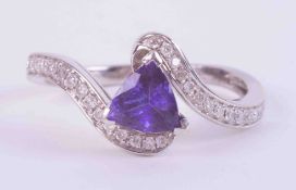 An 18ct white gold cross-over style ring set with a central trilliant cut tanzanite, approx. 0.65