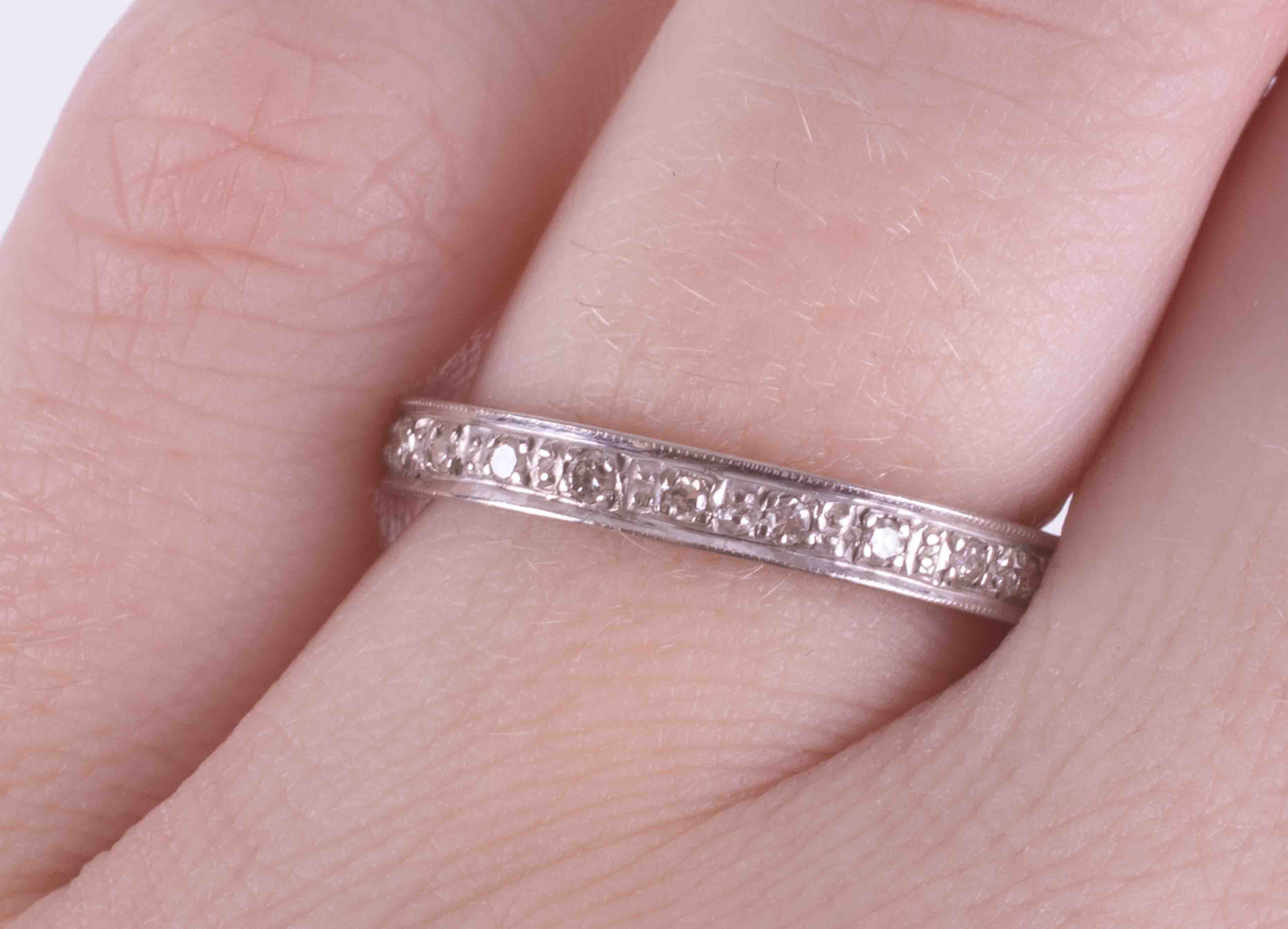An 18ct white gold full eternity ring set with small old cut diamonds and engraving on the edges, - Image 2 of 2