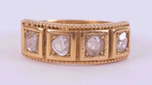 An antique 18ct yellow gold ring set with four old cut diamonds of varying oval shape, total