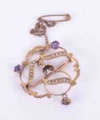 An antique 9ct yellow gold ornate design brooch set with amethysts and seed pearls, the central