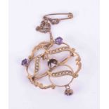 An antique 9ct yellow gold ornate design brooch set with amethysts and seed pearls, the central