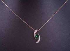 A 9ct yellow gold 18" fine curb chain with a 9ct yellow gold pendant set with an oval cut green