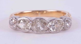 An 18ct yellow & white gold five stone ring with engraved shoulders and set with two old