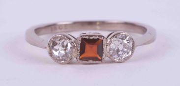 An 18ct white gold three stone ring set with a central square cut garnet, approx. 0.18