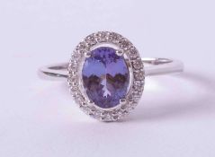 An 18ct white gold cluster ring set an oval cut 1.10 carat tanzanite surrounded by 0.17 carats of