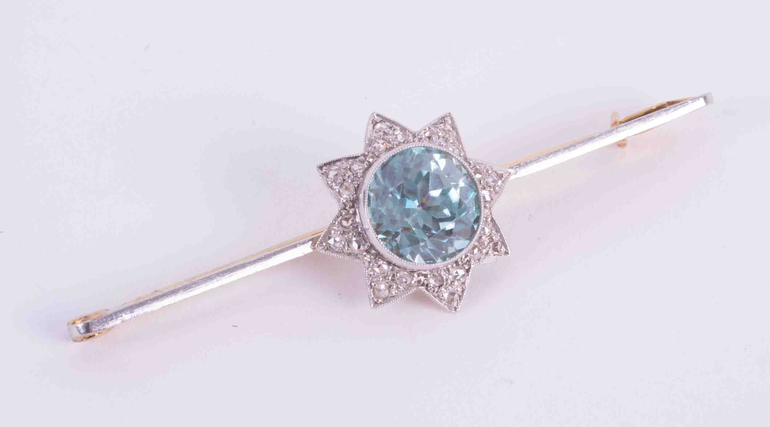 A 15ct yellow & white gold bar brooch set with approx. 2.43 carats of round cut blue zircon and