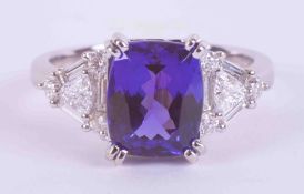 An impressive 18ct white gold ring set with a central cushion cut Tanzanite approx. 3.35 carats, AAA