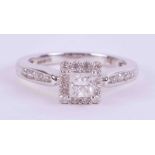 An 18ct white gold ring set with a central princess cut diamond surrounded by small round