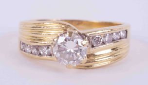 An 18ct yellow gold ring with lined designed shoulders and set with a central round brilliant cut