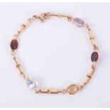 An 18ct yellow gold bracelet set with oval cut multi-coloured gemstones including blue topaz,