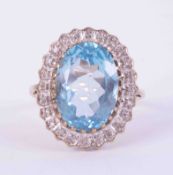 A 9ct yellow gold cluster ring set with a cetral oval cut blue topaz, approx. 6.40 carats,