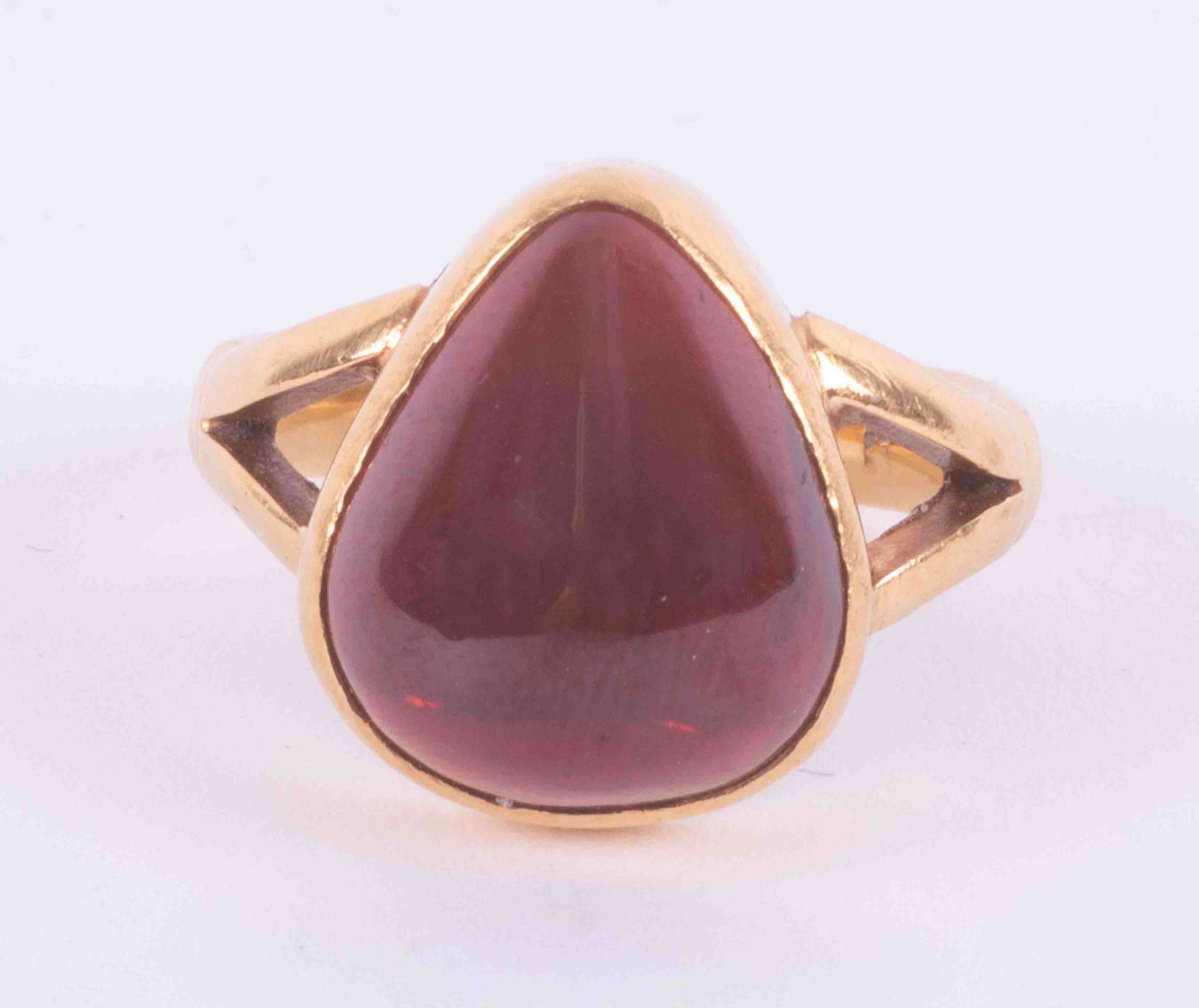 A 22ct yellow gold ring set with a pear shaped cabochon cut garnet, measuring approx. 15mm x 13mm,