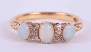 An 18ct yellow gold ring (no hallmarks & not tested) set with three oval cut cabochon white opals,