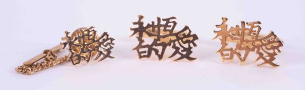 A pair of 18ct yellow gold Chinese symbol cufflinks and a matching tie pin, total weight 13.62g.