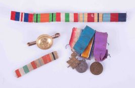 A miniature trio of Great War medals together with a Military badge brooch with ribbons.