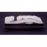 A Chinese carved white jade belt buckle, depicting a dragon on a dragon bridge, length 9cm on a