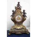 A large 20th Century French metal clock surmounted with cherubs, with enamel and cartouche dial with