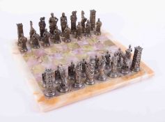 A complete set of thirty two silver and gold coloured chess pieces with a green onyx board.