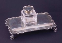An Edwardian silver inkwell and stand, the oblong tray with Chippendale style edge on scrolled