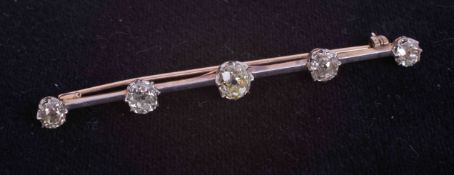 A yellow & white gold (not hallmarked or tested) bar brooch set with five old cut diamonds some