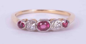 An 18ct yellow & white gold (not hallmarked or tested) five stone ring set three rubies, one oval