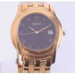 Gucci, a gold plated date wristwatch with black dial, boxed.