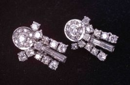 A pair of ornate white gold (not hallmarked or tested) drop earrings set with a mixture of round