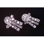 A pair of ornate white gold (not hallmarked or tested) drop earrings set with a mixture of round