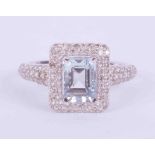 An 18ct white gold ring set with 0.95 carats of emerald cut Aquamarine, surrounded by 0.65 carats