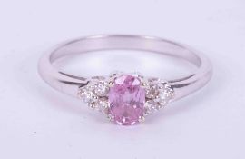 An 18ct white gold ring set with a central oval cut pink sapphire, approx. 0.50 carats with a