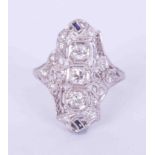 An ornate platinum Art Deco ring set centrally with three older round cut diamonds, total weight